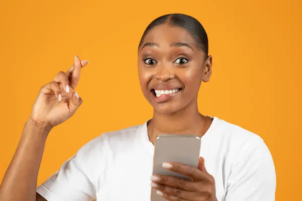 Hopeful Young Black Woman Poses Crossing Her Fingers While Using — Stock Photo, Image