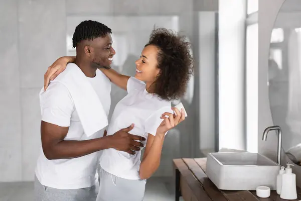 Happy Black Couple Embraces Bathroom Sharing Skincare Moments Woman Holds — Stock Photo, Image