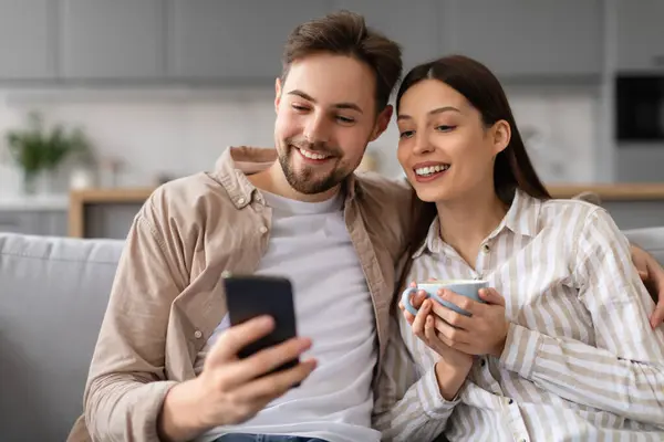 Joyeux Jeunes Conjoints Partageant Sourire Sur Smartphone Avec Une Tasse — Photo