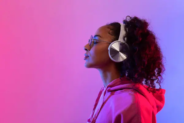 Kablosuz Kulaklıklı Barışçıl Siyahi Kadın Müzikle Kaybolmuş Kapüşonlu Güneş Gözlüklü — Stok fotoğraf