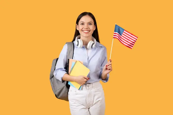 Promienna Studentka Nosząca Zeszyty Słuchawki Szyi Trzyma Amerykańską Flagę Ucieleśniając — Zdjęcie stockowe
