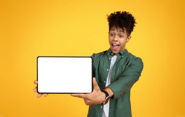 Beyaz ekranlı dijital tablet gösteren afro-amerikan genç adam, öğrenci iyi bir eğitim mobil uygulaması öneriyor ya da online kurs öneriyor, maket, sarı arka plan