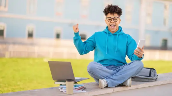 Learning Prestaties Joyful Zwarte Student Met Smartphone Laptop Schudden Vuisten — Stockfoto