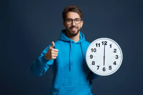 Handsome Smiling Young Man Holding Large Clock Showing Thumb Camera — Stock Photo, Image