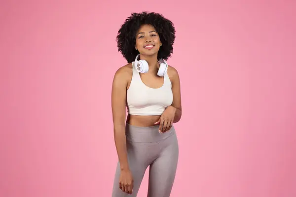Wesoła Afroamerykanka Kręconymi Włosami Uśmiechnięta Ubrana Odzież Sportową Białe Słuchawki — Zdjęcie stockowe