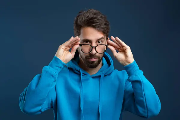 Joven Hombre Ajustando Sus Gafas Con Ambas Manos Mirando Cámara — Foto de Stock