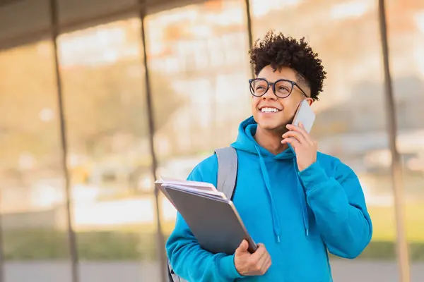 Gelukkige Zwarte Student Die Telefoneert Zijn Laptop Werkboeken Buiten Houdt — Stockfoto