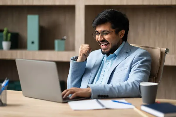 Sukces Biznesie Ekscytowany Indyjski Biznesmen Laptopie Świętujący Zwycięstwo Wnętrzu Biura — Zdjęcie stockowe