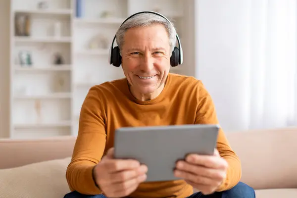 Homem Idoso Bonito Sorridente Feliz Usando Tablet Digital Fones Ouvido — Fotografia de Stock