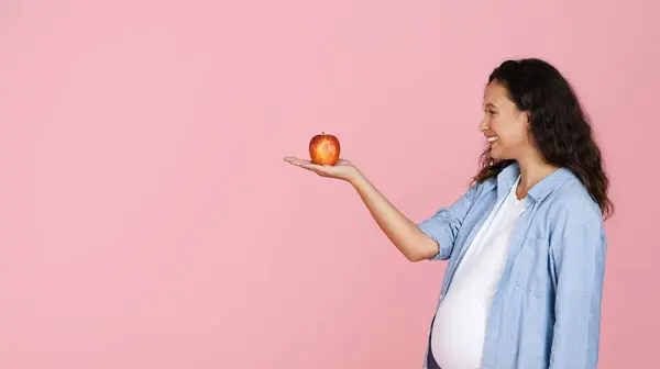 Улыбающаяся Красивая Молодая Беременная Женщина Смотрящая Красное Органическое Яблоко Ладони — стоковое фото