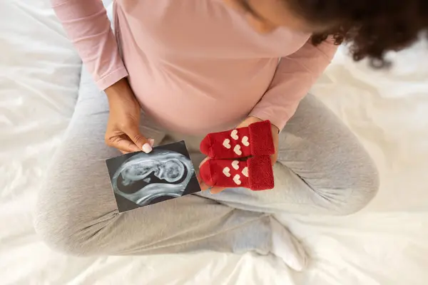 Těhotná Žena Při Pohledu Ultrazvuk Fotografie Rozkošné Červené Dětské Ponožky — Stock fotografie