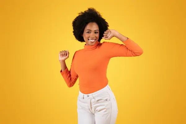 Glada Unga Afroamerikanska Kvinna Med Lekfull Blinkning Dans Orange Polotröja — Stockfoto