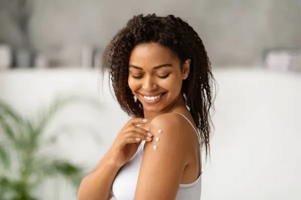 Omzuna Vücut Losyonu Sürerken Gülümseyen Neşeli Siyahi Kadın Mutlu Afro — Stok fotoğraf