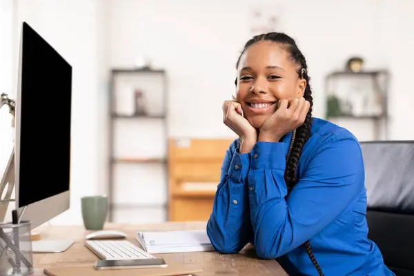 スマートフォンとコンピュータで彼女の机に座って 自宅からオンラインで勉強する彼女の手の上にブレードで黒人女性の学生を笑う — ストック写真