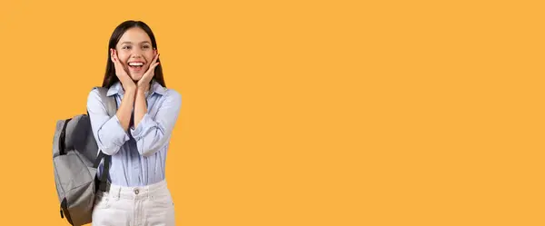 Student Lady Backpack Stands Yellow Background Hands Cheeks Portraying Moment — Stock Photo, Image