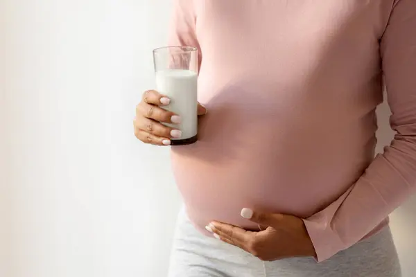 Hamile Bir Kadın Karnını Doyuruyor Elinde Bir Bardak Süt Tutuyor — Stok fotoğraf