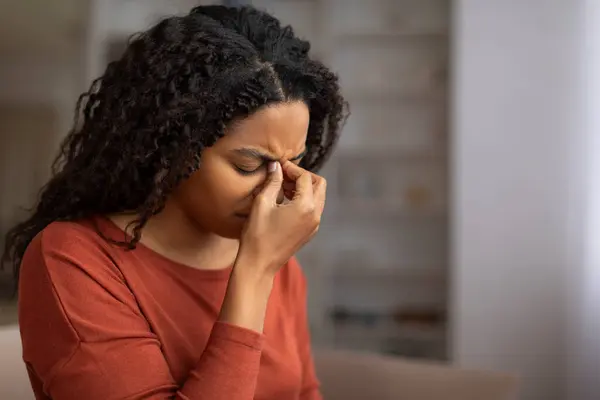 年轻的黑人妇女感到鼻窦疼痛 压在鼻梁上 生病的非洲裔美国妇女闭上眼睛 皱着眉头 在家里表现出不适或头痛的迹象 特写镜头 — 图库照片