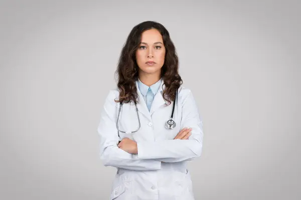 Portrait Confident Woman Doctor Folded Arms Looking Camera Standing Grey — Stock Photo, Image
