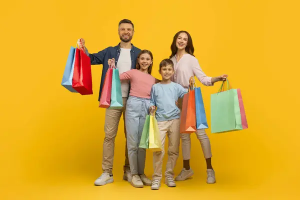 Aile Alışverişi Neşeli Genç Ebeveynler Çocukları Parlak Alışveriş Çantalarını Tutarken — Stok fotoğraf