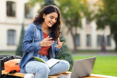 Doğulu genç kız öğrencilerin online sınavları ya da öğretmenleriyle uzaktan randevuları var, dışarıda dizüstü bilgisayar kullanıyorlar, üniversite kampüsünde bankta oturuyorlar, fotokopi çekiyorlar. Modern eğitim