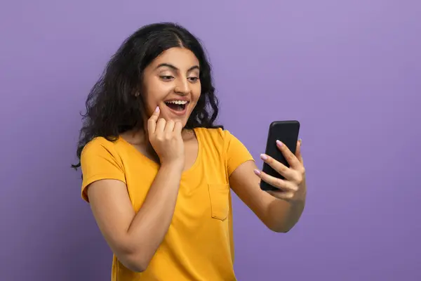 Jovem Mulher Exultante Examina Sua Tela Smartphone Com Uma Reação — Fotografia de Stock