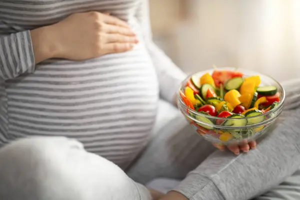 Gravid Kvinna Som Håller Skål Med Färsk Grönsakssalt Medan Sitter — Stockfoto
