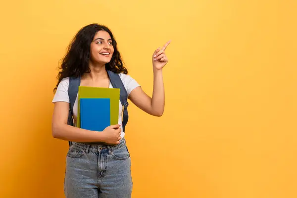 Curious Female Student Pointing Upwards Posing Blue Notebooks Indicating Interest — Stock Photo, Image