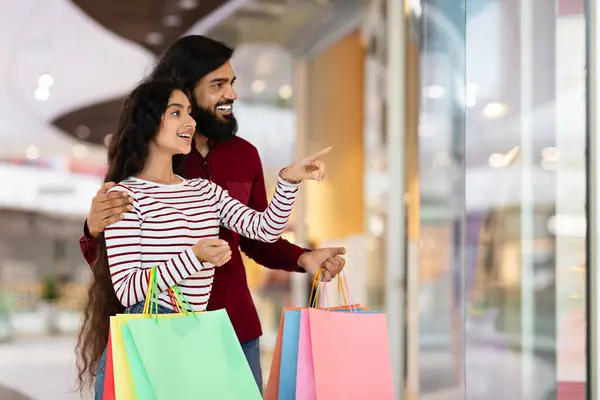 ロマンチックな魅力的なミレニアルインドカップルは ショップウィンドウを指し ショッピングモールを歩き カラフルな紙袋の購入を運び 販売シーズンを楽しんで 素晴らしい割引 コピースペース — ストック写真