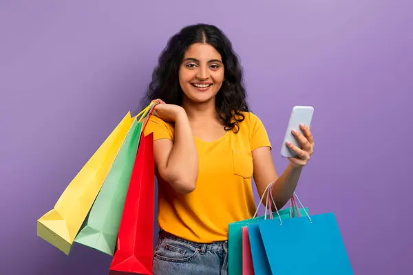 Woman Yellow Top Smiles Holding Shopping Bags Smartphone Suggesting Positive — Stock Photo, Image