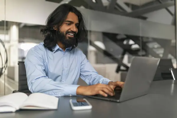 Uzun Saçlı Gözlüklü Gülümseyen Bir Adam Ofisteki Bir Masada Dizüstü — Stok fotoğraf