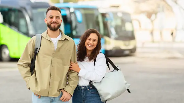 Wesoła Młoda Para Plecakiem Torbą Stojąca Przed Autobusami Lotnisku Szczęśliwy — Zdjęcie stockowe