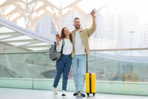 Mutlu Genç Bir Çift Havaalanında Beklerken Pasaportlarını Biniş Kartlarını Havaya — Stok fotoğraf