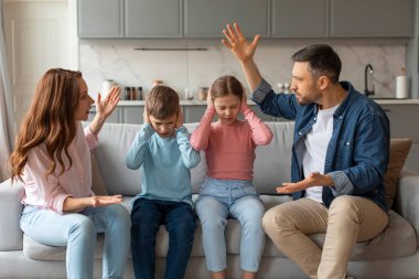 Yurtiçi Quarrels. Evde çocuklarının önünde tartışan erkek ve kadın, küçük kardeşlerinin elleri kulaklarını tıkayan, çatışmaları dinlemeyen, bağıran ebeveynler arasında oturan stresli çocuklar.