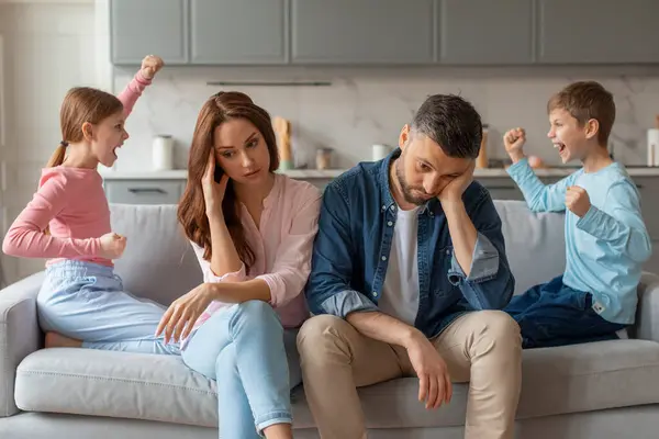 Two Preteen Children Screaming Each Other While Stressed Parents Sitting — Stock Photo, Image