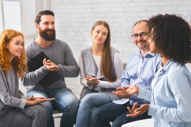 Genç siyahi kadın terapi seansında hikayesini anlatıyor. Grup üyeleri onu alkışlıyor..