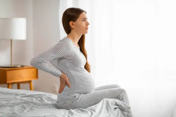 Expectant Mother Striped Shirt Stands Holding Her Back Suggesting Pregnancy — Stock Photo, Image
