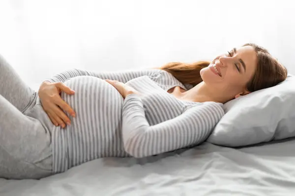 Gravid Kvinna Liggande Rygg Sängen Händerna Magen Visar Känsla Avkoppling — Stockfoto