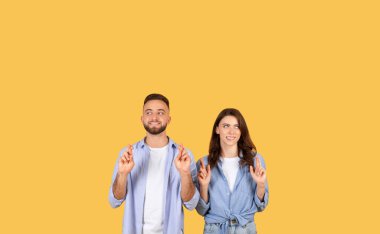 Umut dolu ifadeleri olan bir erkek ve kadın, şans dilemek için şans diliyor.