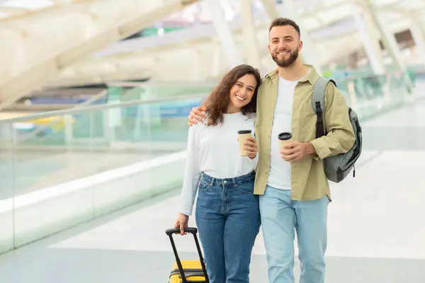 空港でコーヒーカップや荷物を持っている笑顔の男女は 旅行者や休暇中であることを示唆しています — ストック写真