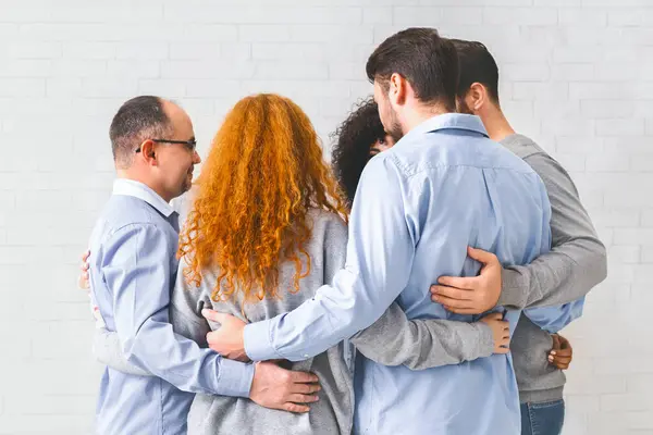 Circle of trust. Group of people hugging in circle and supporting each other, panorama, empty space