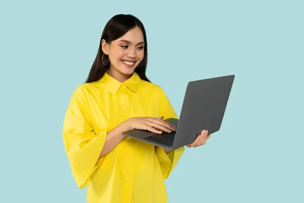 若い幸せな笑顔 ラップトップを使用してヒスパニック女性 タイピングレポートマーケティング担当者 ブルーカラーの背景の上に隔離 — ストック写真