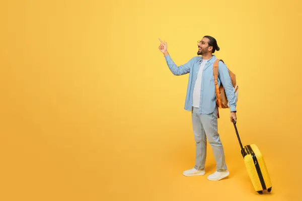 外出先のインド人男性は 目の引く黄色の背景に示される冒険の準備ができて手の荷物でタクシーを運ぶ — ストック写真