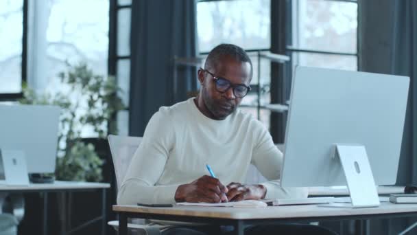 Hombre Está Sentado Escritorio Enfocado Pantalla Computadora Portátil Escribiendo Trabajando Clip De Vídeo