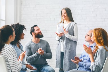 Bağımlılıktan arınmış. İyileşme öyküsünü rehabilitasyon seansında grup ile paylaşan mutlu kadın.
