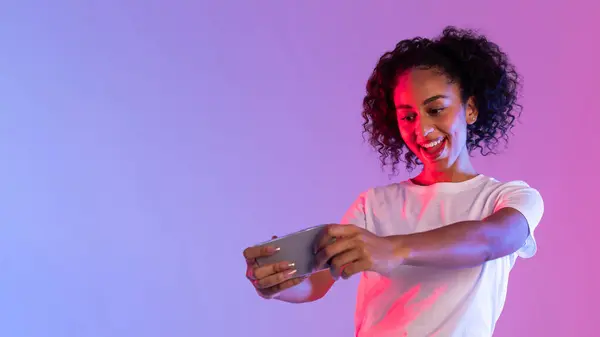 Neon Pembe Mor Bir Arka Planla Oyun Oynarken Akıllı Telefonuna — Stok fotoğraf