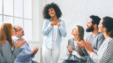 Terapi başarılı oldu. Minnettar Afrikalı Amerikalı kadın terapi seansında başarısını rehabilitasyon grubuyla paylaşıyor.