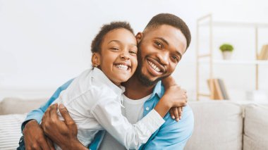 Babalık kavramı. Sevgili baba-kız kucaklaşıp kameraya gülümsüyorlar.