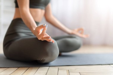 Kadınların el hareketlerinin yakın plan çekimi yoga mudra jesti, tanınmaz halde kadın fitness minderi üzerinde meditasyon yapıyor, dingin ev meditasyonu sırasında farkındalık ve rahatlama egzersizleri yapıyor.