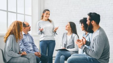 İlerlemesini rehabilitasyondaki terapi grubuyla paylaşan neşeli kadın.