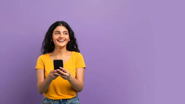 Glimlachende Jonge Vrouw Met Behulp Van Haar Smartphone Kijken Omhoog — Stockfoto